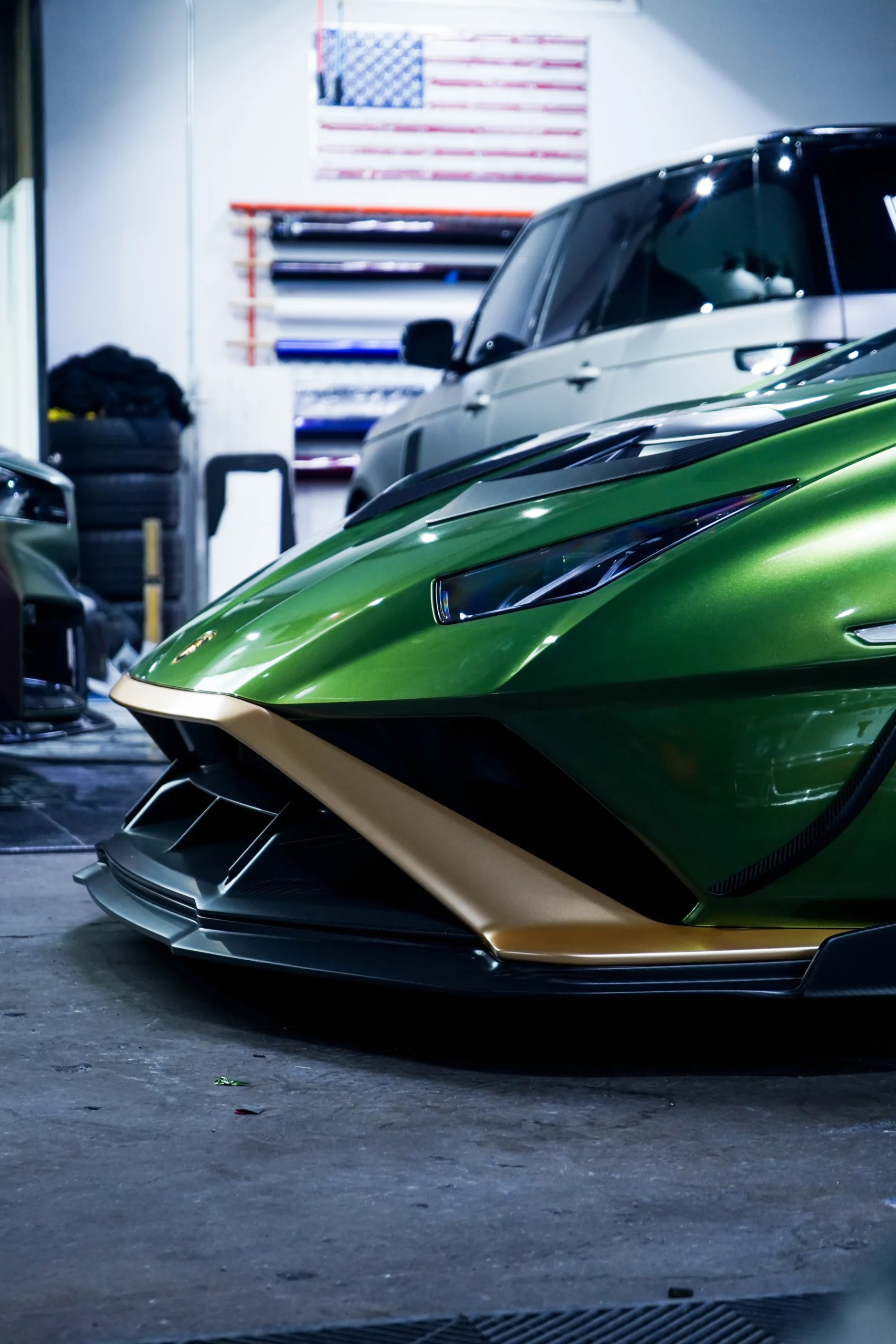 Rear quarter view of a green Lamborghini Huracan with dramatic rear wing in the Aerowerkz shop